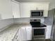 Modern kitchen with stainless steel appliances, granite countertops, and white cabinets at 295 Green Meadows Dr, Taylorsville, NC 28681