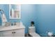 Light blue powder room with a modern sink, white cabinets, and decorative coral for a fresh, clean style at 302 Patterson'S Bridge None, New London, NC 28127