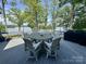 Outdoor deck features dining table and chairs with wooded waterfront views at 302 Patterson'S Bridge None, New London, NC 28127