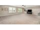 Spacious bonus room with neutral carpet, two windows, and ceiling fan at 3028 Quinebaug Rd, Fort Mill, SC 29715