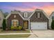 Inviting brick and stone home features a two-car garage, colorful landscaping, and attractive curb appeal at 3028 Quinebaug Rd, Fort Mill, SC 29715