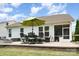 Paver patio features an outdoor dining set with a large umbrella and screened in porch for relaxing and entertaining at 3028 Quinebaug Rd, Fort Mill, SC 29715