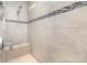 The tiled shower features sleek fixtures, a convenient seat, and elegant accent strips, providing a relaxing experience at 3028 Quinebaug Rd, Fort Mill, SC 29715