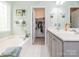 Bathroom showing walk-in closet view with a double vanity, tub, and a window at 3033 Beech Ct, Indian Trail, NC 28079