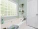 Relaxing bathroom with a soaking tub, a patterned glass block window, and soothing natural light at 3033 Beech Ct, Indian Trail, NC 28079