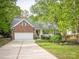 Charming front exterior with well-manicured lawn, garden, and a two-car garage at 3033 Beech Ct, Indian Trail, NC 28079