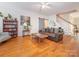 Bright living room featuring hardwood floors, a sliding barn door, and staircase at 3033 Beech Ct, Indian Trail, NC 28079