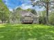 Green backyard showcasing a deck, lush lawn, and plenty of trees at 312 Peach St, Shelby, NC 28150