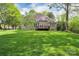 A spacious backyard features a deck, a well-manicured lawn, and mature trees at 312 Peach St, Shelby, NC 28150