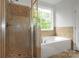 Bright bathroom features a glass-enclosed shower and separate soaking tub beneath a window at 312 Peach St, Shelby, NC 28150