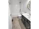 Bathroom features a shower-tub combo with a dark vanity and neutral tile at 312 Peach St, Shelby, NC 28150