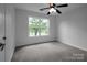 A bright bedroom features carpet, a ceiling fan, and a large window at 312 Peach St, Shelby, NC 28150