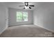 A bright bedroom features carpet, a ceiling fan, and a large window at 312 Peach St, Shelby, NC 28150