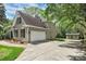 Side view of home featuring an attached two-car garage, shed, and wide driveway at 312 Peach St, Shelby, NC 28150