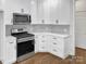 Bright white kitchen featuring stainless steel appliances and light gray backsplash at 312 Peach St, Shelby, NC 28150