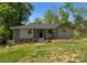 Charming single-story home with gray painted brick and siding, black front door, landscaped yard, and inviting curb appeal at 3423 Sudbury Rd, Charlotte, NC 28205