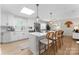 Well-lit kitchen featuring white cabinets, stainless steel appliances, a center island with seating, and modern pendant lighting at 3423 Sudbury Rd, Charlotte, NC 28205