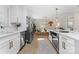 Open-concept kitchen showcasing stainless steel appliances, white cabinetry, hardwood floors, and seamless flow to dining area at 3423 Sudbury Rd, Charlotte, NC 28205