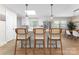 Bright kitchen island with white countertop, wood chairs, stainless appliances, and sleek modern pendant lighting at 3423 Sudbury Rd, Charlotte, NC 28205