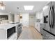 Bright kitchen featuring white cabinets, stainless steel appliances, a center island with seating, and modern pendant lighting at 3423 Sudbury Rd, Charlotte, NC 28205