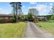 Long driveway leading to the brick home surrounded by mature trees and lush landscaping at 365 Pine Hill Rd, Salisbury, NC 28144