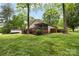 Home's backyard with a wooden deck, screened-in porch, and views of lush greenery and the golf course at 3764 Glenn Oaks Dr, Maiden, NC 28650