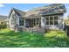 Backyard showcasing a covered patio, outdoor kitchen, stone firepit, and lush green lawn at 4012 Brandywine Ter, Lancaster, SC 29720