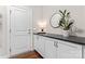 Inviting entryway featuring white cabinets, black countertop, round mirror, and lovely plant decor at 4012 Brandywine Ter, Lancaster, SC 29720