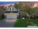 Charming home at dusk showcasing stone accents, manicured lawn, a three-car garage and mature trees at 4012 Brandywine Ter, Lancaster, SC 29720