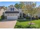Charming home showcasing stone accents, manicured lawn, a three-car garage and mature trees at 4012 Brandywine Ter, Lancaster, SC 29720