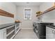 Bright laundry room features front-load machines, folding counter, stylish baskets, and natural light at 4012 Brandywine Ter, Lancaster, SC 29720