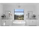 Luxurious bathroom with dual vanities, soaking tub, and a large window showcasing the outdoors at 405 Sugar Maple Ln # 41, Weddington, NC 28104