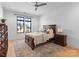 Bedroom with wood flooring, ceiling fan, neutral colors, and view to the front yard from large windows at 405 Sugar Maple Ln # 41, Weddington, NC 28104