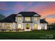 Stunning two-story home with a manicured lawn and elegant architectural details, illuminated at twilight at 405 Sugar Maple Ln # 41, Weddington, NC 28104