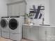 Laundry room featuring modern washer and dryer, ample storage, sink with white counter, and stylish decor at 405 Sugar Maple Ln # 41, Weddington, NC 28104