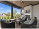 Covered patio with outdoor fireplace, TV, grill, and comfortable seating overlooking beautiful landscaping and lake at 405 Sugar Maple Ln # 41, Weddington, NC 28104