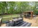 Large deck with outdoor kitchen, dining table, and lounge area overlooking a spacious backyard at 4517 Lake Shore N Rd, Denver, NC 28037