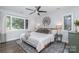Inviting bedroom with a ceiling fan, large windows, and a comfortable bed with throw blanket and decor at 4517 Lake Shore N Rd, Denver, NC 28037