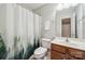 This cozy bathroom has a commode, sink with vanity, shower and decorative curtain at 4648 Craigmoss Ln, Charlotte, NC 28278