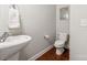 Half bathroom with modern sink, toilet, and decorative wall art; functional and stylish at 4648 Craigmoss Ln, Charlotte, NC 28278