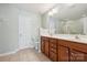 Bright bathroom featuring a double vanity with wood cabinets and tiled floors at 4648 Craigmoss Ln, Charlotte, NC 28278