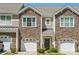 Charming townhome featuring a stone facade, attached garage, and inviting entryway at 4648 Craigmoss Ln, Charlotte, NC 28278