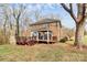 Backyard with deck featuring a gazebo and a stone fireplace, surrounded by mature trees at 503 Bridgestone Ct, Gastonia, NC 28056