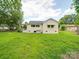 Back exterior featuring a large yard, the brick home has many windows, and a small awning over one window at 511 Hasty St, Marshville, NC 28103