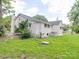 Back exterior featuring a small patio and yard, the brick home has a small staircase and white trim at 511 Hasty St, Marshville, NC 28103