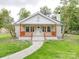 Inviting front exterior featuring a quaint porch with wood accents and a well-manicured lawn at 511 Hasty St, Marshville, NC 28103