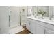 Bathroom featuring double sinks, white cabinets, and a shower at 5232 Reedy Ridge Rd, Charlotte, NC 28215