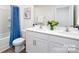 Bathroom with double sinks, white cabinets, toilet and tub with blue curtain at 5232 Reedy Ridge Rd, Charlotte, NC 28215