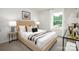 Bright bedroom with a tufted headboard, bedside table, and a large window providing natural light and outdoor views at 5232 Reedy Ridge Rd, Charlotte, NC 28215