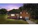 Charming brick home with a well-manicured lawn, attached garage, and inviting front porch under a dusky sky at 5301 Baker Dr, Charlotte, NC 28210